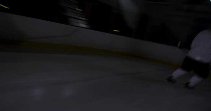 Ice hockey scene on dark rink dramatic players and goalie during a game