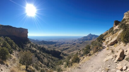 Obraz premium Scenic Mountain Landscape with Bright Sun and Clear Blue Sky