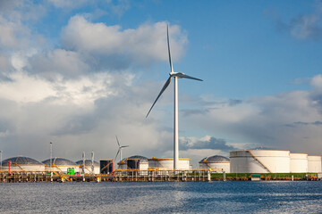 Onshore oil storage near the seaport and wind turbines on the shore.