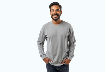 Fototapeta premium A commercial portrait photo of a model on a white studio background: a man standing with his hands in his pockets, wearing a grey long sleeve t-shirt and smiling against a white background.