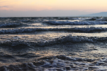 Sunset at sea. Beautiful sunset landscape on the Balearic Sea. View of the sea with small waves. View of the waves on the sea from a lower angle. Salou, Spain