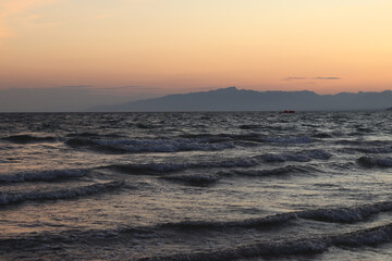 Sunset at sea. Beautiful sunset landscape on the Balearic Sea. View of the sea with small waves. View of the waves on the sea from a lower angle. Salou, Spain