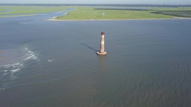 Aerial orbiting shot of the abandoned Morris Island Lighthouse between Charleston and Folly Beach, South Carolina.