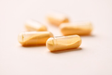 Coenzyme Q10 capsules. Antioxidants. Concept for a healthy dietary supplementation. Bright paper background. Soft focus. Close up. Copy space.	