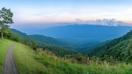 Obraz premium Scenic View of Lush Green Valley with Mountain Range and Blue Sky Panorama