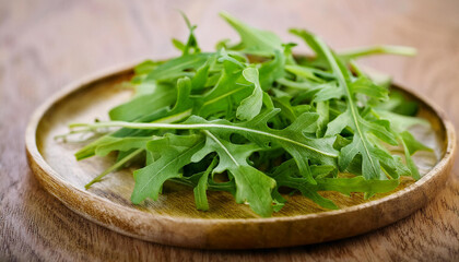 Green arugula on wooden plate. Healthy and natural product. Rucola leaves.