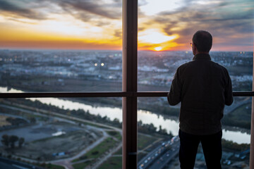 Fototapeta premium Person enjoys sunset view from Torre Sevilla observation deck in Seville