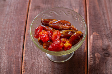 Dogwood, dried dates large sweet in glass container on wooden table