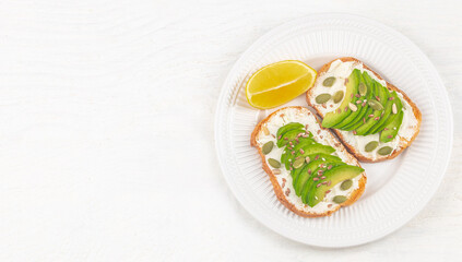 Healthy food, Two avocado toasts with cream cheese and seeds for breakfast on white table background, top view