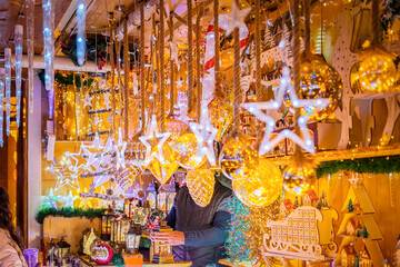 Christmas market stall decorated with golden ornaments. Concept of festive holiday decoration, seasonal celebration