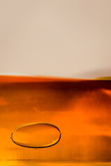 abstract close-up of white wine bottle amber glass containing golden liquid with bubble surface tension art isolated on white background