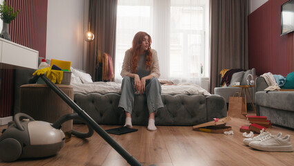 Exhausted sad upset Caucasian woman girl female homeowner lady housewife tired headache stress anxious frustrated mess in bedroom cleaning home chore problem trouble messy dirty housekeeping cleanup