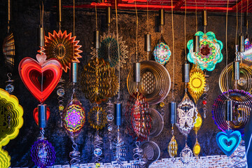 Colorful wind spinners displayed in market stall. Concept of vibrant decoration, creative ornaments