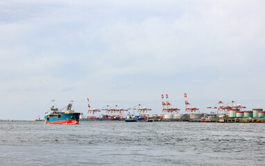 Cargo transportation and activity at modern shipping container terminal.