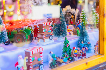 Miniature Christmas village scene with trees and figurines in window . Concept of festive decoration, winter holiday