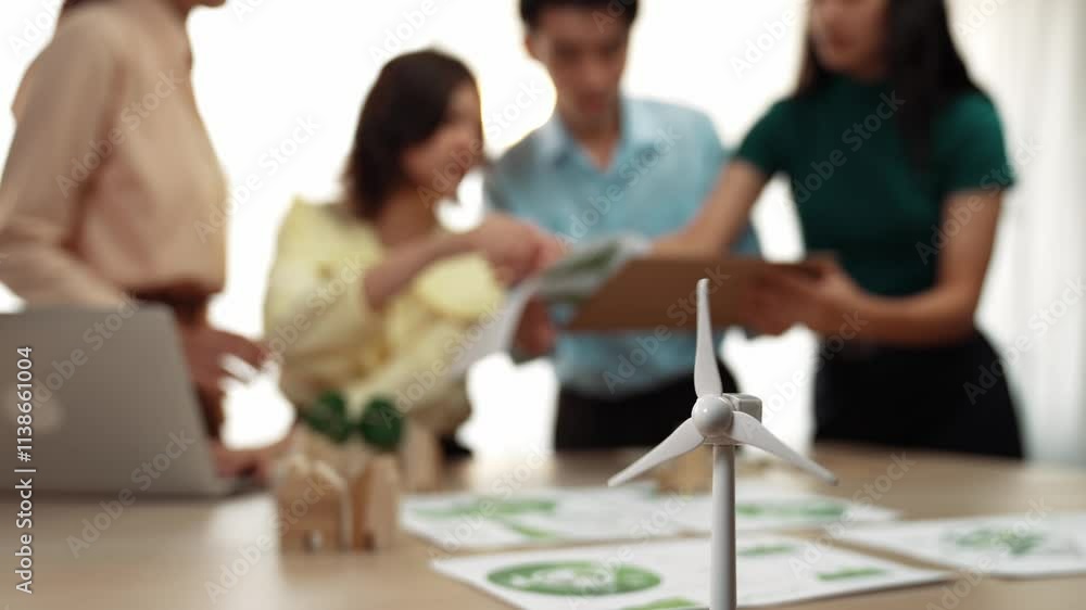 Poster windmill model represented using green energy and wooden block symbolized eco house was on table in 