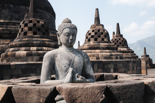 BUDDHA SITTING ON THE TOP OF THE UNESCO BOROBUDUR TEMPLE IN JAVA INDONESIA 