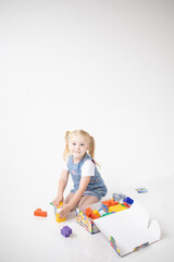 Educational Toys: The Child Develops Motor Skills With The Help Of Colorful Cubes on a white background. The girl is playing with cubes