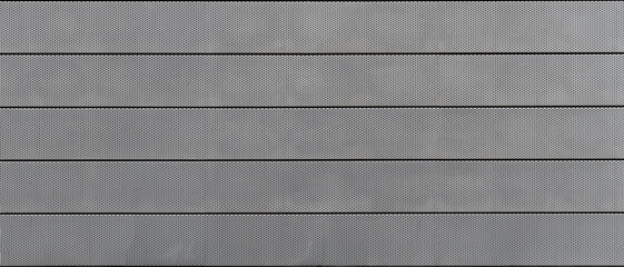 Panoramic view of metallic texture with a pattern of small holes and horizontal lines