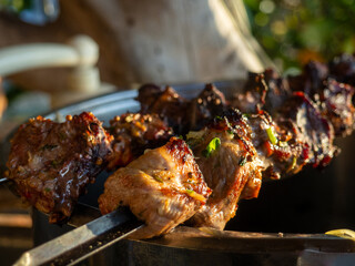 Shashlik on a skewer close-up. Fried meat with smoke. Home cooking. Cuisine of the peoples of the world.