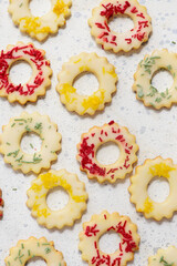 Christmas cookies lemon rings with colorful sprinkles on a Christmas rustic background
