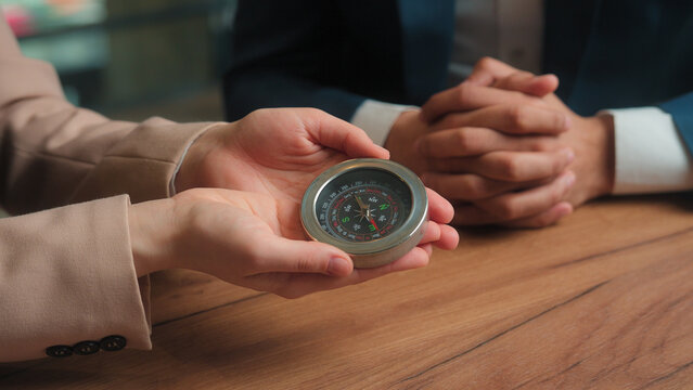 Businessman businesswoman Arabian man Muslim woman in hijab male female business partners hold compass search direction navigation in financial world rotating pointer trade stock market money success - Powered by Adobe