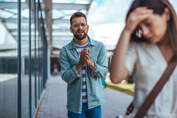 Man Apologizing to Woman Outdoors with Expressive Body Language