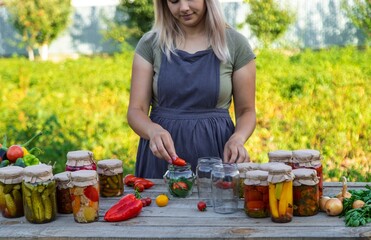 A woman preserves vegetables in jars. Selective focus.