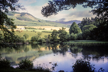 Vintage photograph of a view over a lake with hills and mountains in the distance