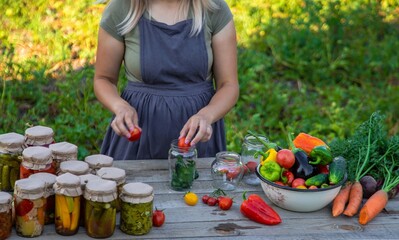 A woman preserves vegetables in jars. Selective focus.