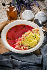 Red borscht soup in bowl.