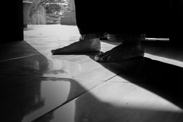 Silhouette of Feet Standing in the Doorway – Mysterious Low Light Concept
