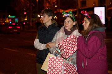 Family enjoying christmas shopping at night with illuminated reindeer antlers
