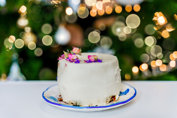 A cake on the background of a Christmas tree, a festive atmosphere of the new year