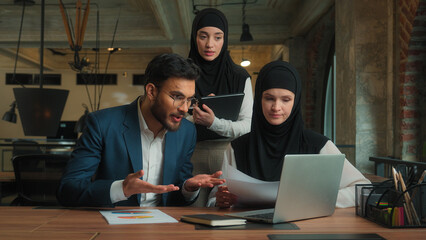 Arabian business team work in office Muslim women businesswomen Indian businessman man male female talk laptop video chat online conference call meeting angry mad leader displeased sales graph problem