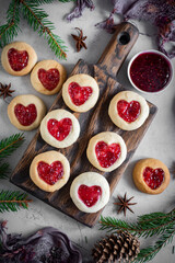 Sweet dessert: Cookies with jam in the shape of a heart. Sweet cookies for a romantic breakfast on a gray background. Cookies for a loved one. Vertical photo. Close-up