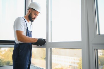 Construction worker installing window in house