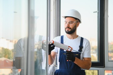 Hands applying silicone sealant that defending from water leaks and mildew. Home repair and...