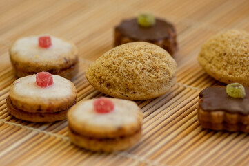 Various kinds of tasty Christmas chocolate, nuts and filled cookies on japanese wooden mat