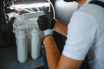 Plumber installs or change water filter. Replacement aqua filter. Repairman installing water filter...