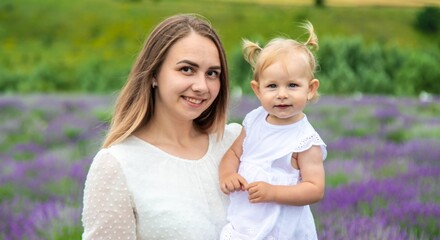 Fototapeta premium Happy mother and daughter in a lavender field
