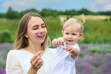 Fototapeta premium Happy mother and daughter in a lavender field