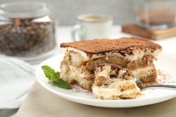 Piece of tasty tiramisu on table, closeup