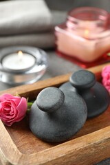 Spa stones, rose flower and candles on table, closeup