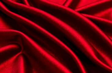 Fototapeta premium Red silk fabric background. Trendy fabric texture close up, elegant folds and soft sheen