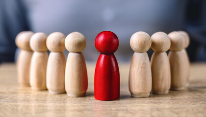 Wooden figurines with one red piece standing out in the center. Uniqueness, leadership or selection