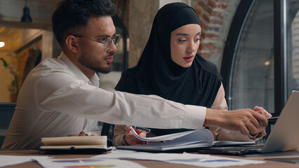 Two business colleagues muslim islamic businesswoman in hijab Arabian businessman working with...