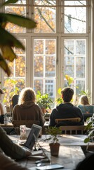 Obraz premium A cozy workspace with people engaged in activities, surrounded by plants and natural light.