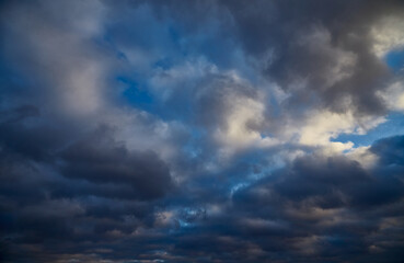 Obraz premium The contrast of a blue sky and gray-white clouds on a winter day.