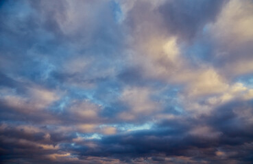 Sunlight pierces gray-white clouds in the cold winter sky.